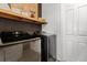 Well-equipped laundry room features modern machines, built in shelving and neutral walls at 8750 Sw 79Th Loop, Ocala, FL 34481