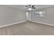 A spacious bedroom with light gray walls, fan, and light, wood-look flooring at 20995 Sw 93Rd Lane Rd, Dunnellon, FL 34431