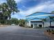 Community center exterior with blue and white accents, palm trees and ample parking at 20995 Sw 93Rd Lane Rd, Dunnellon, FL 34431