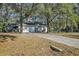 Home featuring a large driveway and an attached garage surrounded by mature shade trees at 20995 Sw 93Rd Lane Rd, Dunnellon, FL 34431