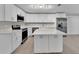 Bright kitchen boasts white cabinets, stainless steel appliances, large island and modern finishes at 20995 Sw 93Rd Lane Rd, Dunnellon, FL 34431