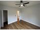 Bedroom with plank floors, light gray walls, ceiling fan, and closet with an open door at 36702 Calhoun Rd, Eustis, FL 32736