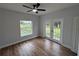 Bedroom with plank floors, light gray walls, ceiling fan, and French doors that lead to yard at 36702 Calhoun Rd, Eustis, FL 32736