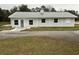 Single-story home featuring light gray siding, a metal roof, and white-framed windows at 36702 Calhoun Rd, Eustis, FL 32736