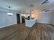 Spacious living room open to the kitchen with modern lighting, plank floors, and light walls at 36702 Calhoun Rd, Eustis, FL 32736