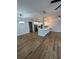 Wide angle living room open to kitchen with wood plank floors, modern lighting, and painted light gray at 36702 Calhoun Rd, Eustis, FL 32736