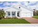 Charming single-story home showcasing a well-manicured lawn and a brick-paved driveway, offering a blend of comfort and curb appeal at 4220 Cattail Marsh Dr, Lakeland, FL 33811