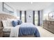 This bedroom has a large bed with blue pillows and a comforter, as well as a gray dresser with lamps on it at 4226 Cattail Marsh Dr, Lakeland, FL 33811
