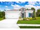 Charming single-Gathering home with a two-car garage, stone accents, lush landscaping, and blue shutters at 4226 Cattail Marsh Dr, Lakeland, FL 33811