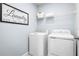 Bright laundry room featuring a washer, dryer, shelving, and modern signage at 4226 Cattail Marsh Dr, Lakeland, FL 33811