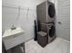Functional laundry room equipped with stacked washer and dryer, utility sink, and convenient wire shelving at 1567 Lake Reserve Dr, Deland, FL 32724