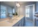 Bright bathroom with double vanity, quartz countertop, decorative towels, and a large mirror at 673 Four Leaf Ave, Debary, FL 32713