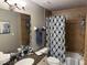 Bathroom with a vanity, neutral wall tones, designer mirror, patterned shower curtain and granite counters at 1425 Ocean Shore Blvd # 402, Ormond Beach, FL 32176