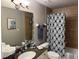 Bathroom with a vanity, neutral wall tones, designer mirror, patterned shower curtain and granite counters at 1425 Ocean Shore Blvd # 402, Ormond Beach, FL 32176