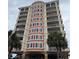 Beautiful multi-story building with balconies, decorative insets, and palm trees at 1425 Ocean Shore Blvd # 402, Ormond Beach, FL 32176