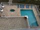 Aerial shot of community pool and hot tub with surrounding lounge chairs at 1425 Ocean Shore Blvd # 402, Ormond Beach, FL 32176