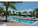 Community pool surrounded by lounge chairs, umbrellas and lush palm trees at 3317 Grande Heron Dr, St Cloud, FL 34773