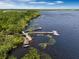 Aerial view of a lake with boat docks, fishing piers, and wooded shoreline under a partly cloudy sky at 3323 Grande Heron Dr, St Cloud, FL 34773