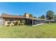 View of the backyard with a screened-in porch, featuring a well-manicured lawn and landscape at 3200 Se 34Th St, Ocala, FL 34471