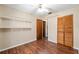 Bedroom featuring updated hard surface floors, a ceiling fan, and ample shelving and closet space at 3200 Se 34Th St, Ocala, FL 34471