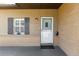 Inviting front entrance with a brick facade, a white door, and a window with dark shutters at 3200 Se 34Th St, Ocala, FL 34471