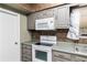 Close up of kitchen featuring gray cabinets, modern white appliances, and tile backsplash at 3200 Se 34Th St, Ocala, FL 34471