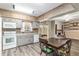 Eat-in kitchen with gray cabinets, wood-look flooring, and view to the brick fireplace and accent wall beyond at 3200 Se 34Th St, Ocala, FL 34471