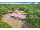 Scenic aerial shot of a home nestled in a serene, tree-filled setting with a long driveway at 4931 Tropicana Dr, Indian Lake Estates, FL 33855