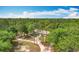 Picturesque aerial view of a charming home surrounded by a lush forest and winding driveway at 4931 Tropicana Dr, Indian Lake Estates, FL 33855