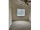 This cozy carpeted bedroom is filled with light from a window and features a ceiling fan at 4931 Tropicana Dr, Indian Lake Estates, FL 33855