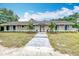 Charming single-story home with a well-manicured lawn, neutral colors, and a brick walkway at 4931 Tropicana Dr, Indian Lake Estates, FL 33855