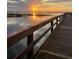 Scenic view of a pier extending into the water during a vibrant sunset at 4931 Tropicana Dr, Indian Lake Estates, FL 33855