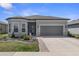 Charming one-story home featuring stone accents, manicured landscaping, and a gray two-car garage at 8534 Sw 59Th Lane Rd, Ocala, FL 34481