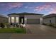 Charming one-story home featuring stone accents, manicured landscaping, and a gray two-car garage at dusk at 8534 Sw 59Th Lane Rd, Ocala, FL 34481