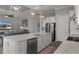 Modern kitchen features an island with a sink and quartz countertop, stainless steel appliances, and stylish light fixtures at 8534 Sw 59Th Lane Rd, Ocala, FL 34481