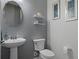 Elegant powder room with pedestal sink, decorative mirror, and stylish shelving at 8534 Sw 59Th Lane Rd, Ocala, FL 34481