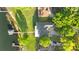 Aerial view of a well-maintained home with a private dock, lush greenery, and ample parking space at 248 Lake Tennessee Dr, Auburndale, FL 33823