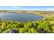 Panoramic aerial view of a vast lake, surrounded by lush trees and featuring homes with private docks along the tranquil shoreline at 248 Lake Tennessee Dr, Auburndale, FL 33823