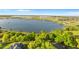 Scenic aerial view of a sprawling lake, showcasing homes with private docks nestled among mature trees and lush landscapes at 248 Lake Tennessee Dr, Auburndale, FL 33823