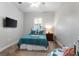 Bedroom with a queen bed with blue patterned bedding, a nightstand, and a wall-mounted television at 248 Lake Tennessee Dr, Auburndale, FL 33823