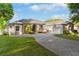 Beautiful home featuring a gray exterior, a well-manicured lawn, a brick driveway, and mature trees at 248 Lake Tennessee Dr, Auburndale, FL 33823