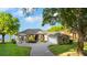 Spacious home with a gray exterior, a well-manicured lawn, mature trees, and a winding brick driveway at 248 Lake Tennessee Dr, Auburndale, FL 33823