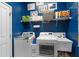 Functional laundry room with washer, dryer, and storage shelves at 248 Lake Tennessee Dr, Auburndale, FL 33823