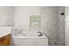 Modern bathroom featuring a soaking tub, a walk-in shower, and a window at 3601 Weatherfield Dr, Kissimmee, FL 34746