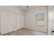 Bright bedroom featuring neutral walls, hardwood flooring, window, and double door closet space at 3601 Weatherfield Dr, Kissimmee, FL 34746