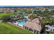 Aerial view of a resort-style community pool, pool house, and palm trees at 3601 Weatherfield Dr, Kissimmee, FL 34746