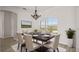 Dining room with a wooden table set for six, complemented by elegant chairs and a chandelier at 3601 Weatherfield Dr, Kissimmee, FL 34746