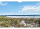 Beautiful beach view with ocean waves and lush vegetation creating a serene coastal landscape at 5244 Luisa Ct, St Cloud, FL 34771