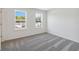 Bright bedroom with soft carpet, neutral paint, and two windows with outdoor view at 5244 Luisa Ct, St Cloud, FL 34771