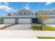 Charming townhome featuring a two-car garage, blue exterior, and well-manicured landscaping at 5244 Luisa Ct, St Cloud, FL 34771
